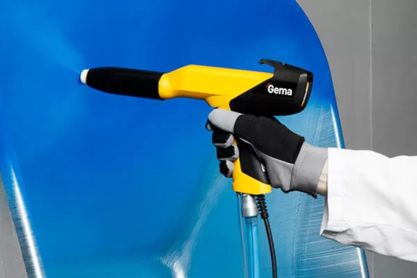 SPM technician applying powder coating with a hand spray gun